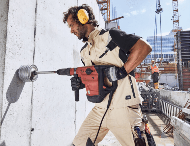 Ein Arbeiter mit Bohrmaschine in eigener Workwear